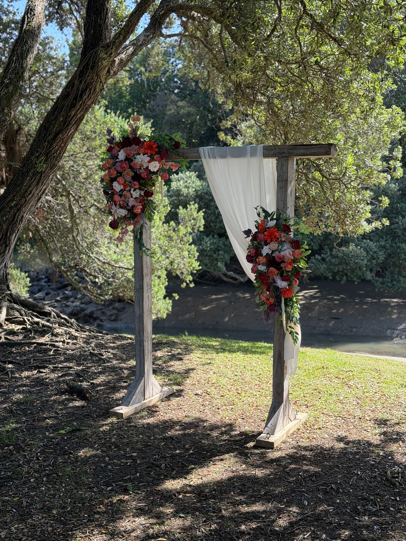 Flower-dressed wedding arch beside Deep Creek