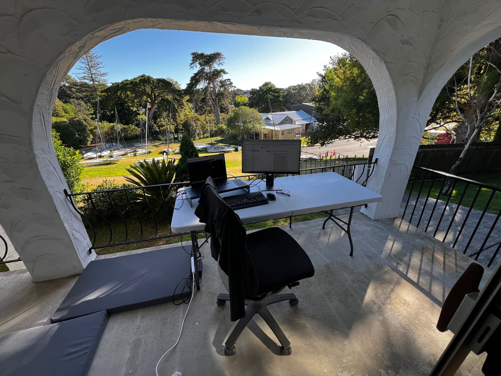 A desk set up on the balcony, looking over Aickin Reserve