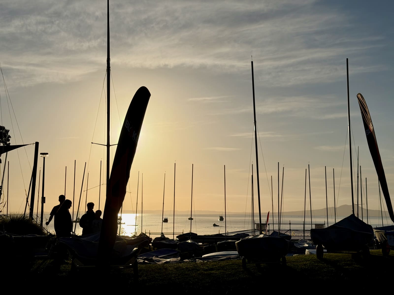 Masts and feather flags silhouetted against the sunrise