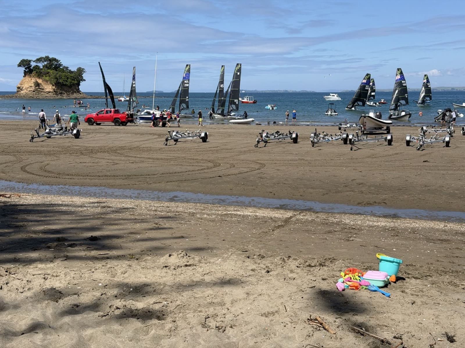 Ein Sommertag am Waiake Beach – Segeljollen, Familien und der Tor